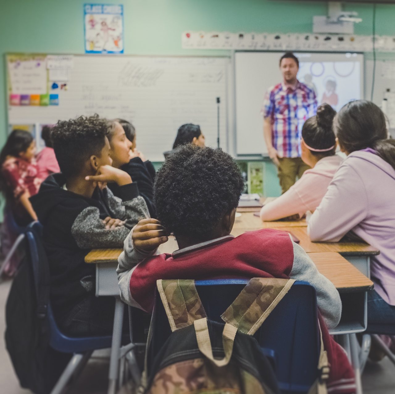 kids in a classroom being taught by a teacher