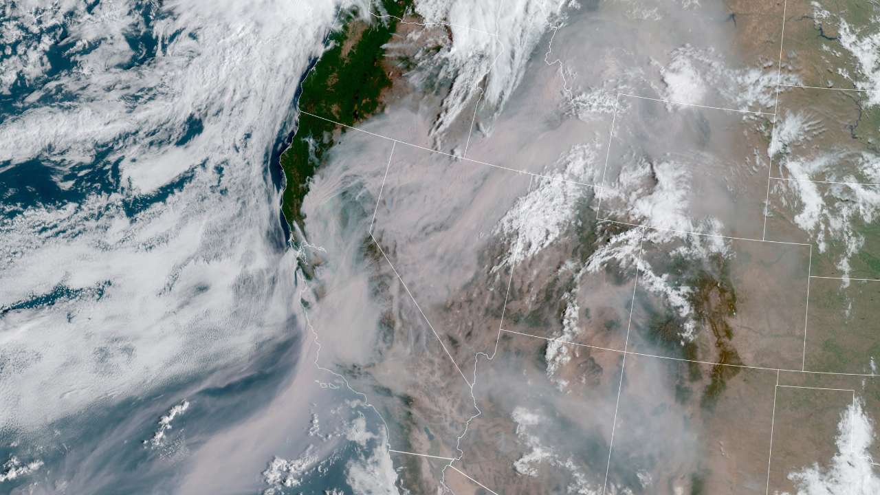 Satellite image of Western U.S. with white, gray, and tan swirls of smoke and clouds.