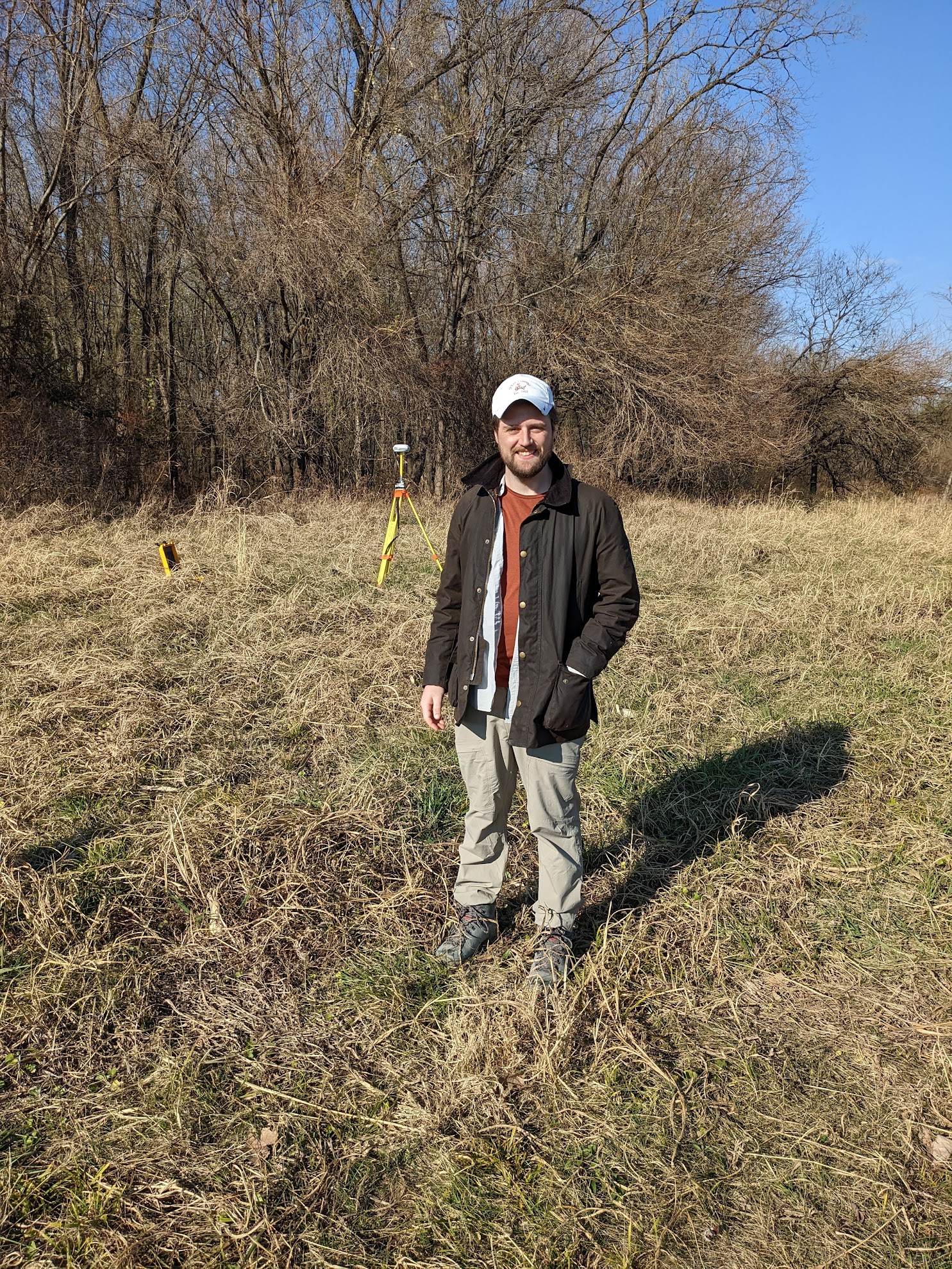 Person standing a field in outdoor gear.