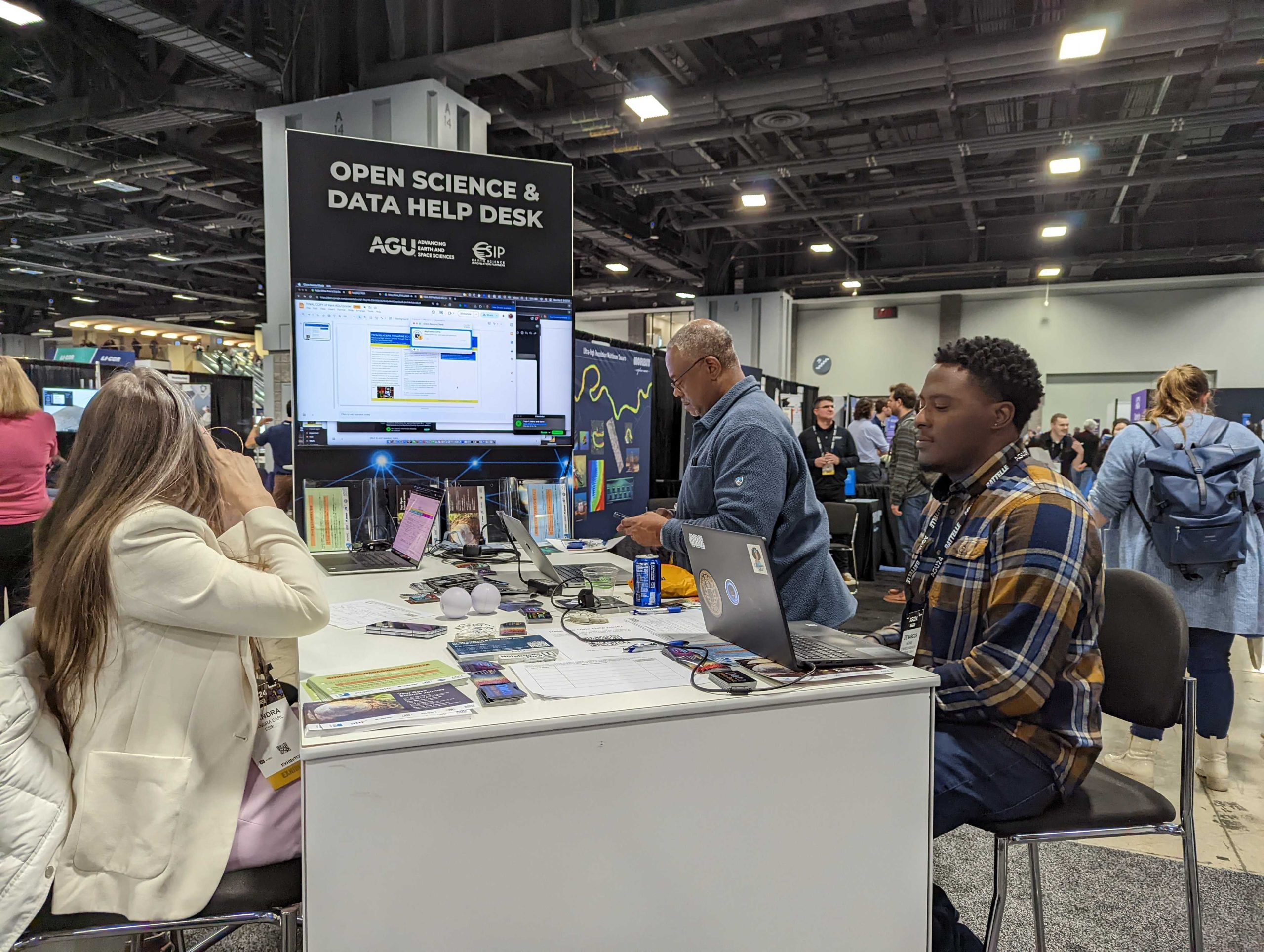 group of people at a table with a large "Open Science & Data Help Desk" sign