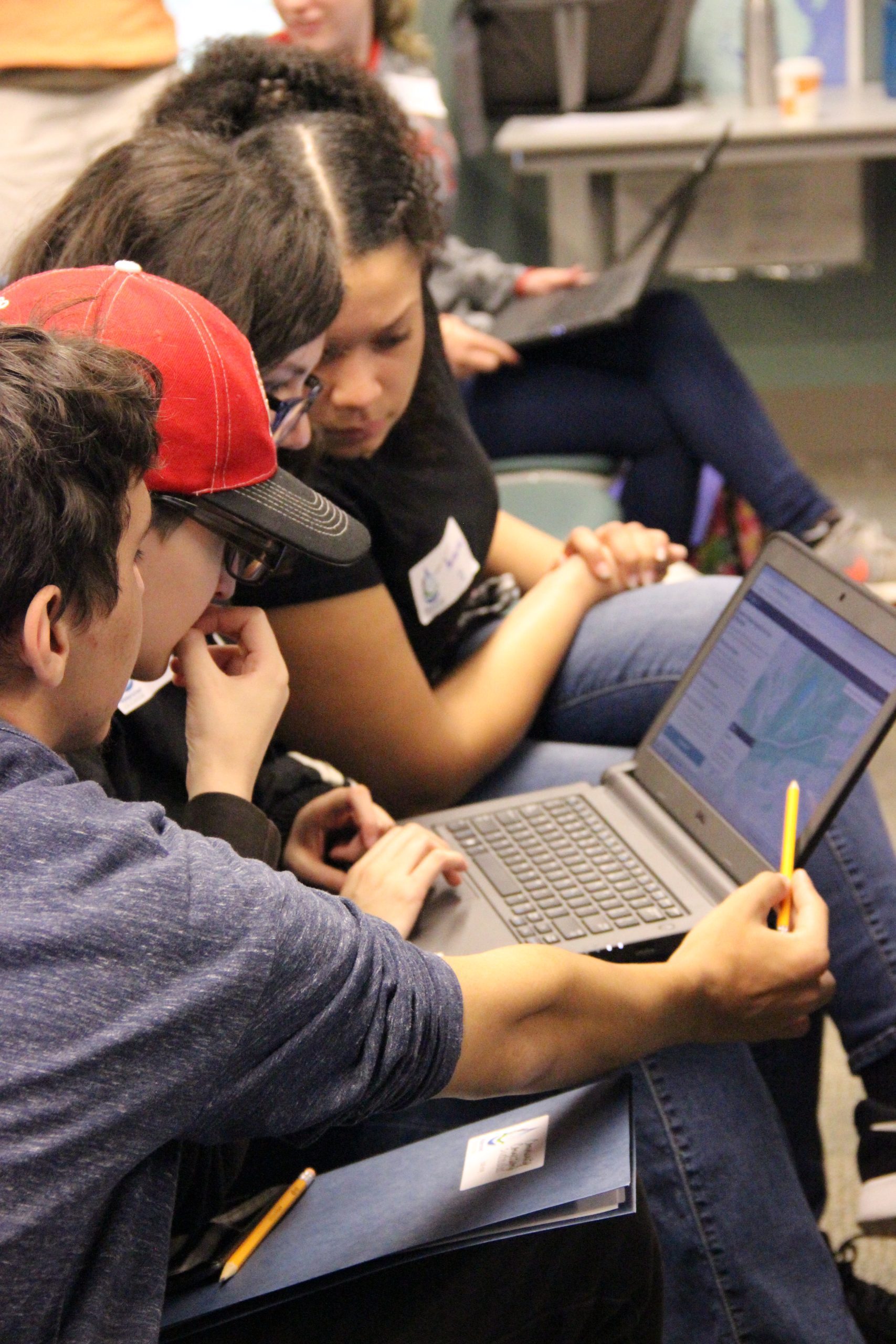 Students working on a laptop computer together.